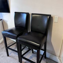 bar stools. Dark brown faux leather with dark wood legs.