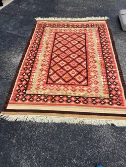 South Westin flat-woven vintage kilim rug featuring a distinctive geometric diamond pattern in shades of rose and beige with fringed ends. 8’ x 5’