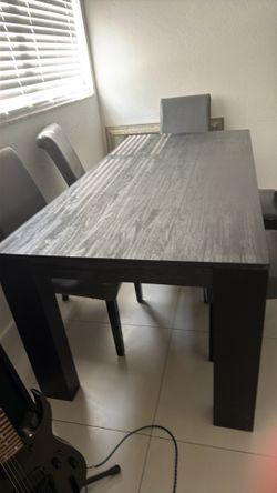 Black wire brush dining room table and five gray leather chair chairs