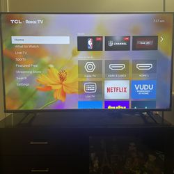 TCL Roku TV And Wooden Cabinet 