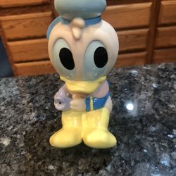 Vintage Disney Baby Donald Duck Soft Rubber Squeaky Toy with a purple fish.  Size 4 1/2 inches tall.  Preowned 