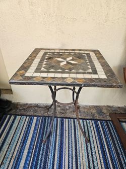 Outdoor tile table. Height is 28 inches, width 24 inches, & depth is 24 inches.