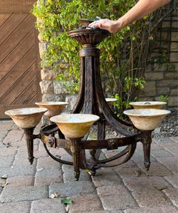 This rustic iron chandelier features six arms with alabaster-style shades and measures approximately