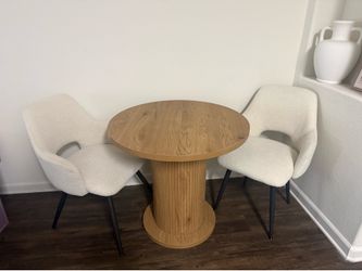 Round Dining table with fluted bass and 2 cream boucle chairs