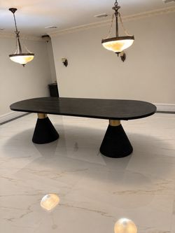 Black Oval Dining Table with Gold Cone Bases