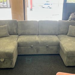 Grey Fabric Couch With A Pull Out Bed And Storage Spaces