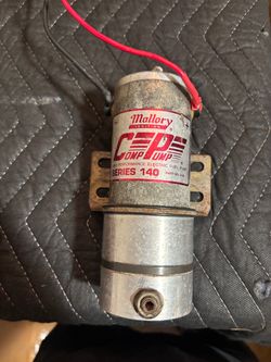 Used high-performance electric fuel pump is a Mallory Ignition Comp Pump Series 140, part number 4140. This silver and gold-toned metal unit has a mou