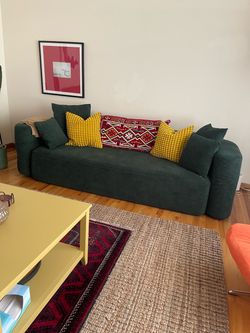 Green sofa couch with pillows