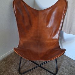 2 - Rustic brown leather butterfly chair with a black metal frame
