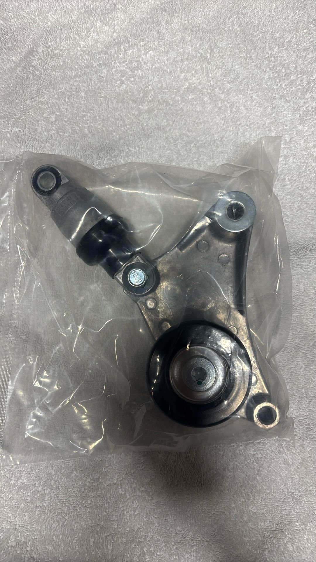 Belt tensioner with pulley assembly