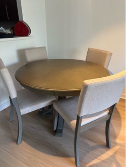 Round dining table with upholstered chairs