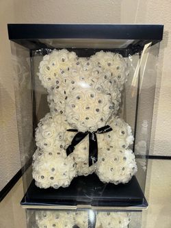 decorative white artificial rose teddy bear adorned with rhinestones inside a clear display box