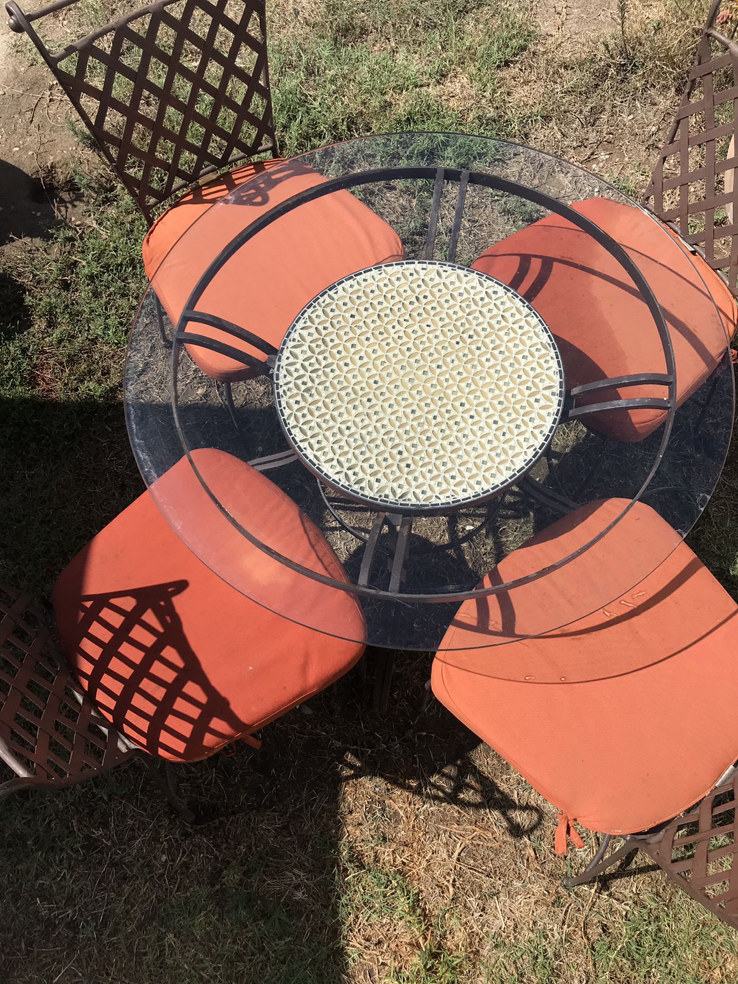 Outdoor iron and mosaic table with glass top. Includes 4 chairs.