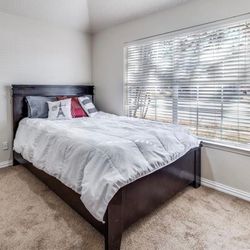 Queen size bed with dark wood frame