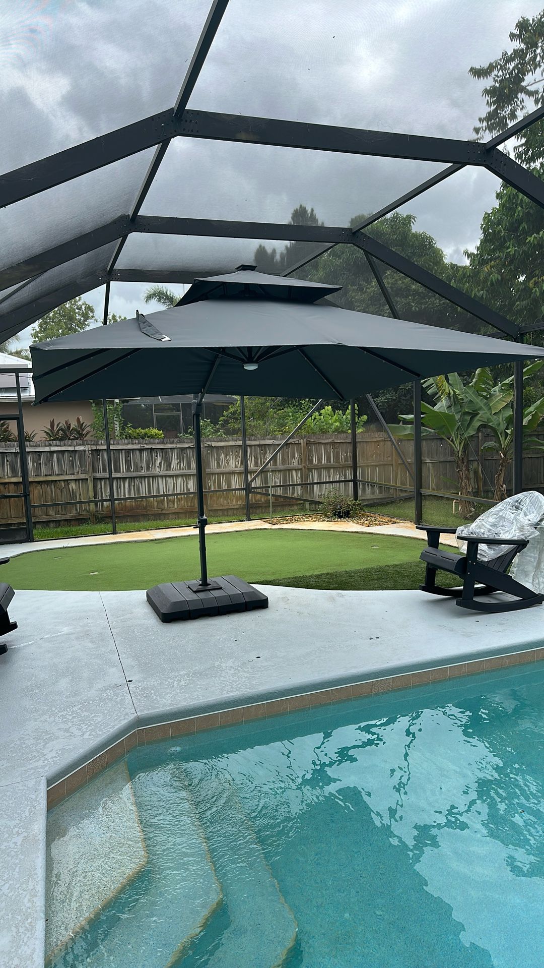 Dark gray patio umbrella with weighted base 10’ x 10’