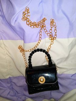 miniature black patent handbag with a gold chain strap and