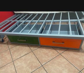 Gray iron bed in very good condition with an orange drawer and a green drawer with plenty of space to store things. It has 4 wheels to be able to move
