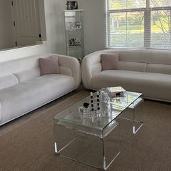 Two identical modern design cream-colored sofas. Soft upholstery. Size: Spacious seating for 3 people.