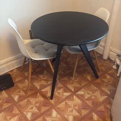 3 Leg Black Table W/ Two White Chairs & Cushions