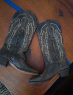 The product is a pair of western women's boots made by the brand Style. They feature a leather upper and outsole with a rubber heel cap, making them d