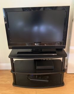 LG 32 Inch TV with remote, attached stand and entertainment unit 