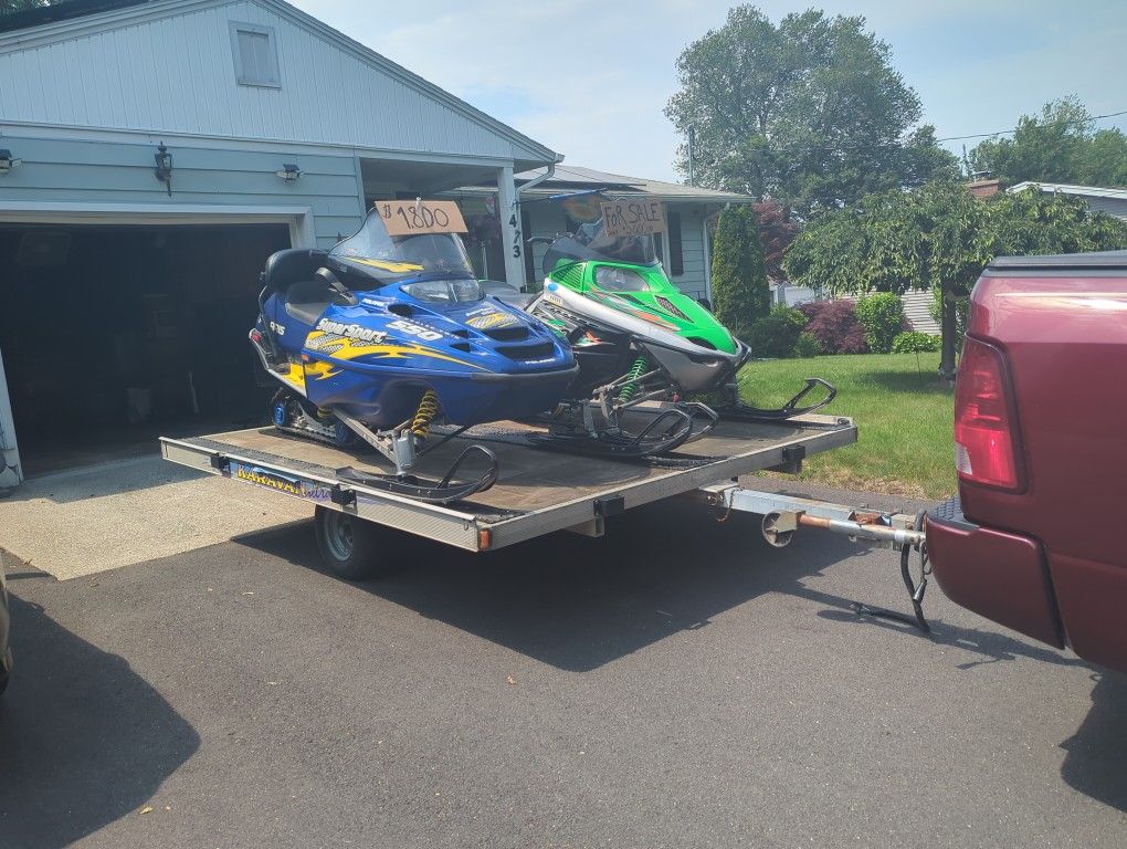 Two Snowmobiles In A Trailer