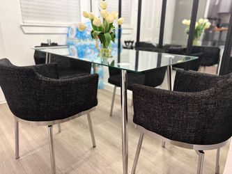 Glass dining table four black swivel chairs