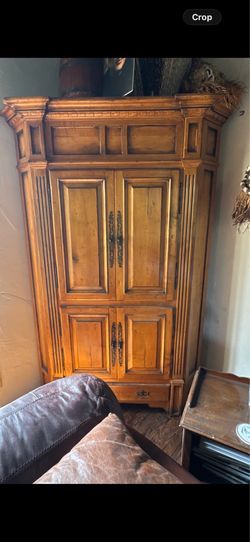 A rustic solid wood armoire designed in a Spanish hacienda style.