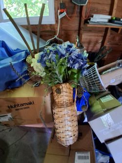 In great condition floor wicker vase with flowers.