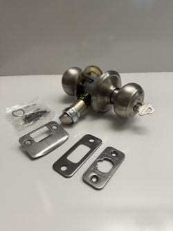 Keyed entry door knob set, which includes a doorknob with a key lock on the exterior and a thumb-turn on the interior. 