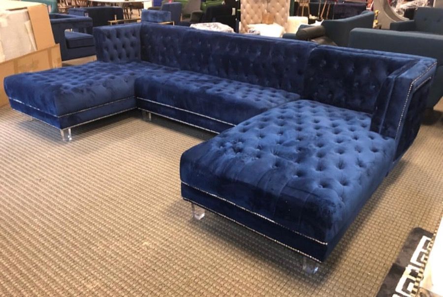 Blue tufted velvet sectional sofa on acrylic legs