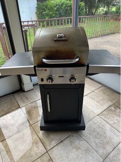 Outdoor grill with two gas tank tanks one is empty one is half full