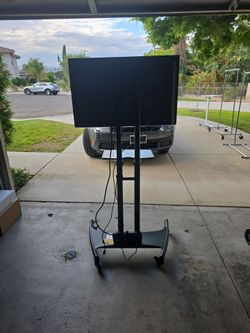 Rolling TV stand with shelf and TV