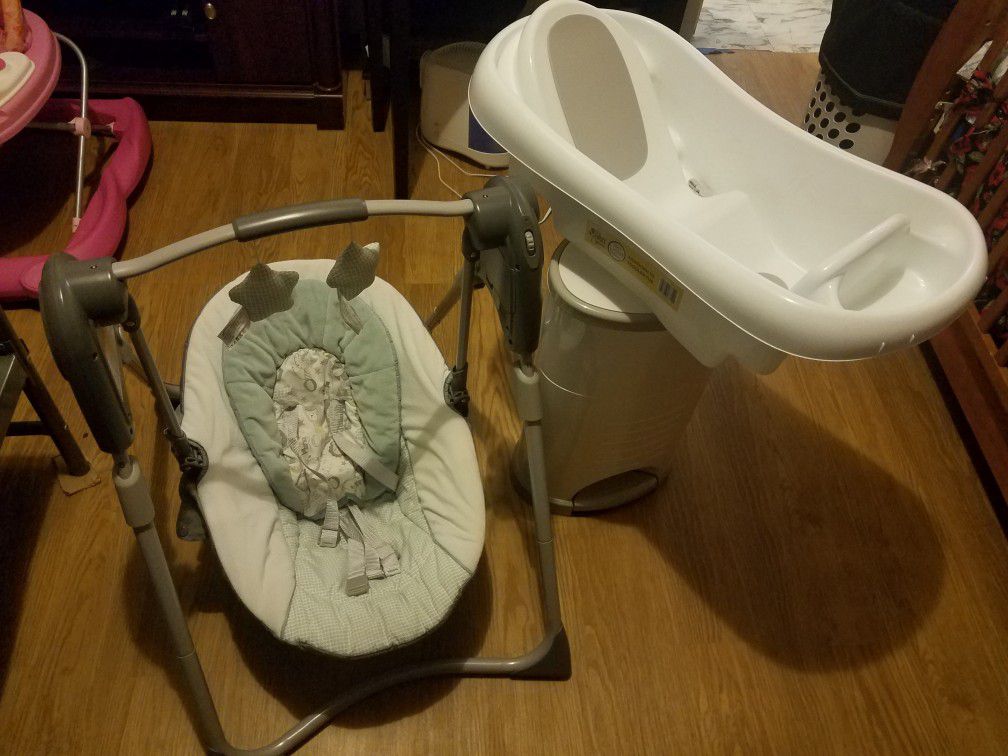 swing for children and trash can for dirty diapers and a baby tub