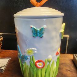 Cheryl's Cookies Cookie jar with flowers and butterfly's. Lid has rubber seal 
6"w x 10.5"h
