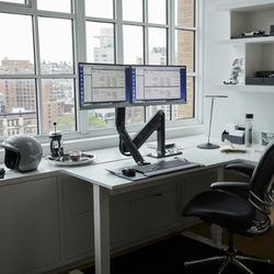 Humanscale adjustable dual monitor stand with keyboard tray.