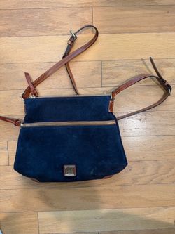 Dooney & Bourke navy blue suede crossbody purse with brown leather trim, gold-tone hardware, and red interior lining.
