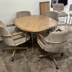 MCM 42” Vintage Wood & Brass Table, 4 Rolling Dining Chairs, 2 Stools, Table Leaf