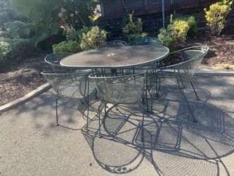 Vintage Woodard Wrought Iron Patio Table and 6 Wrought Iron Chairs With Wrap Around Arm Rests & Umbrella Capability