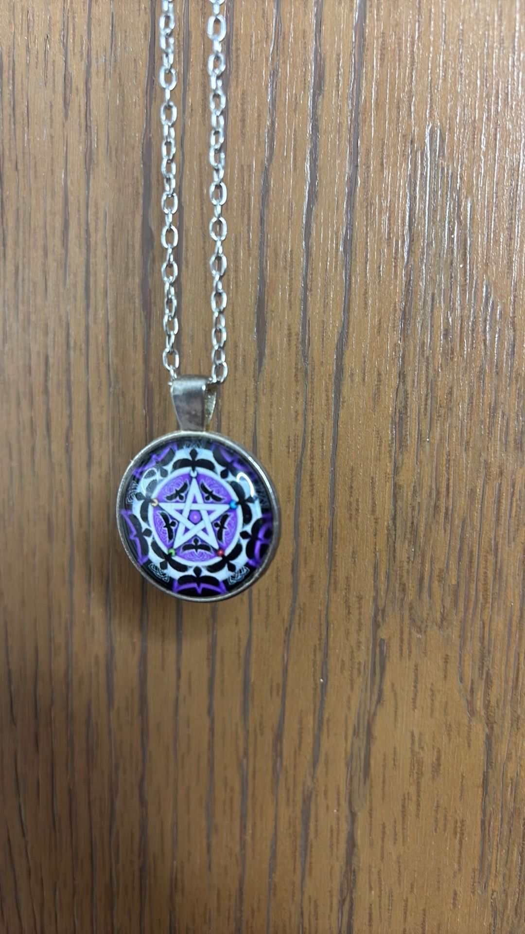 Pendant with purple star pattern on a silver chain with a lobster claw clasp