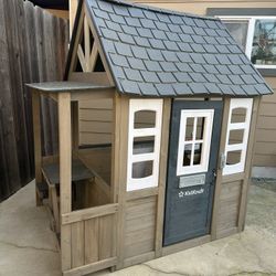 KidKraft wooden playhouse with lunch bench, working door and doorbell, birdhouse