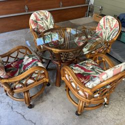 Mid century rattan  kitchen /dining room table and chairs, chairs are swivel with casters 42 in glass top good shape