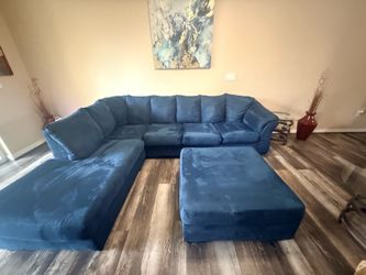 Blue sectional, matching ottoman and glass table set.