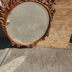 Rococo-style mirror, characterized by its ornate, curving scrolls, carved leaves, and flourishes. 