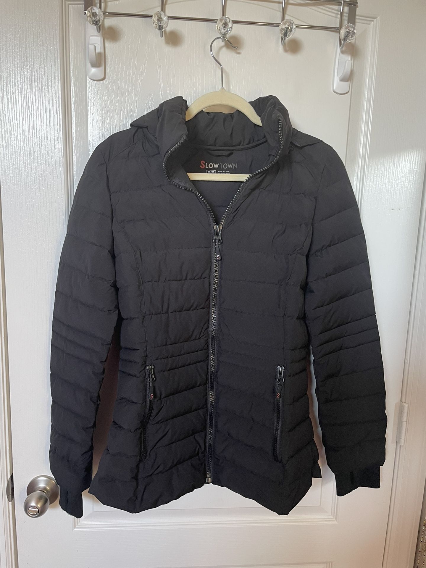 Slowtown Women’s Winter Jacket size M in excellent condition, with hood, zip pockets, and figure flattering fit