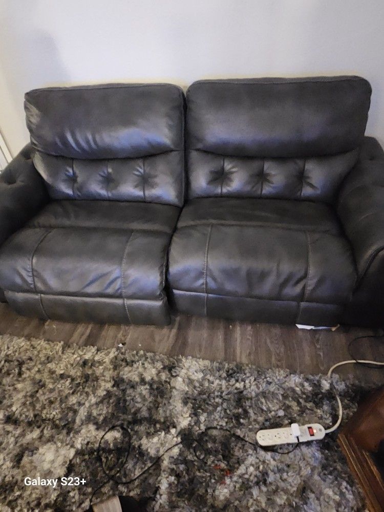Dark Grey Recliner love seat Many different levels to recline, has charger for your phone on the side