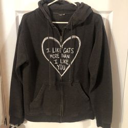 Hooded sweatshirt size Medium.  On the from it has a heart and says “I like cats more than I like you”.  Preowned good condition. 