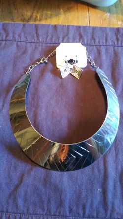 Never worn silver colored choker with matching earrings. Still has the tag on them