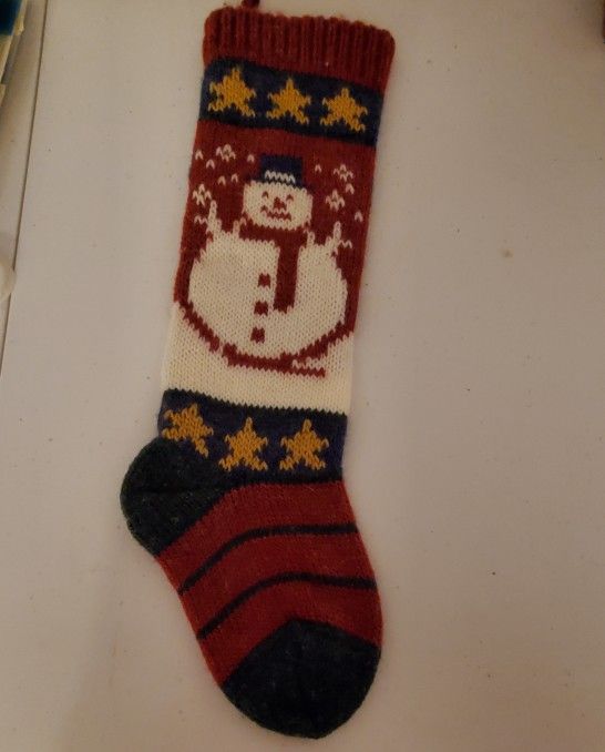 Cozy knit stocking featuring a cheerful snowman design. Perfect for holiday decor.