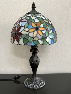 Tiffany-style stained glass table lamp, a vibrant floral design and decorative bronze-finished base